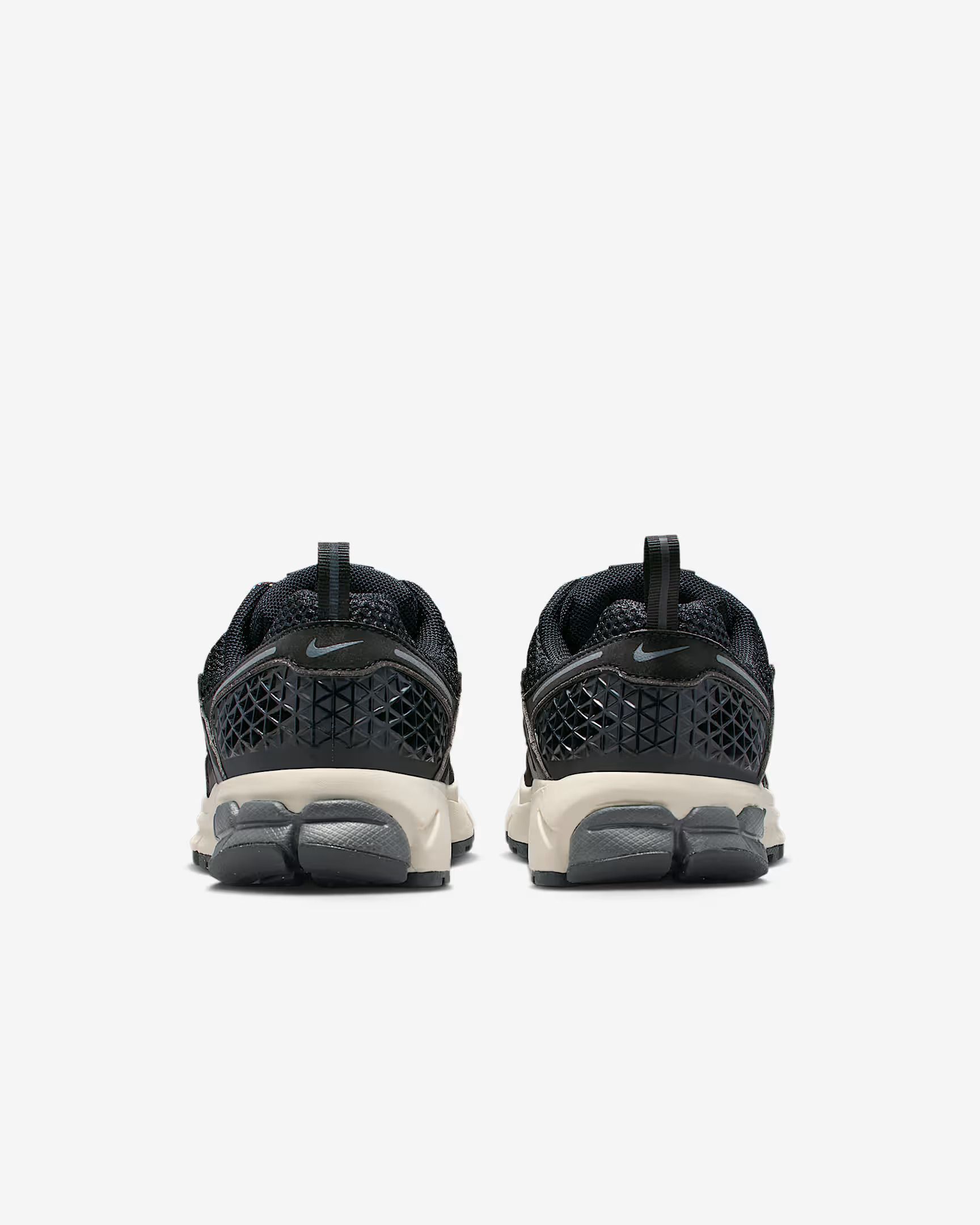 Pair of black sneakers with light soles, viewed from the back.