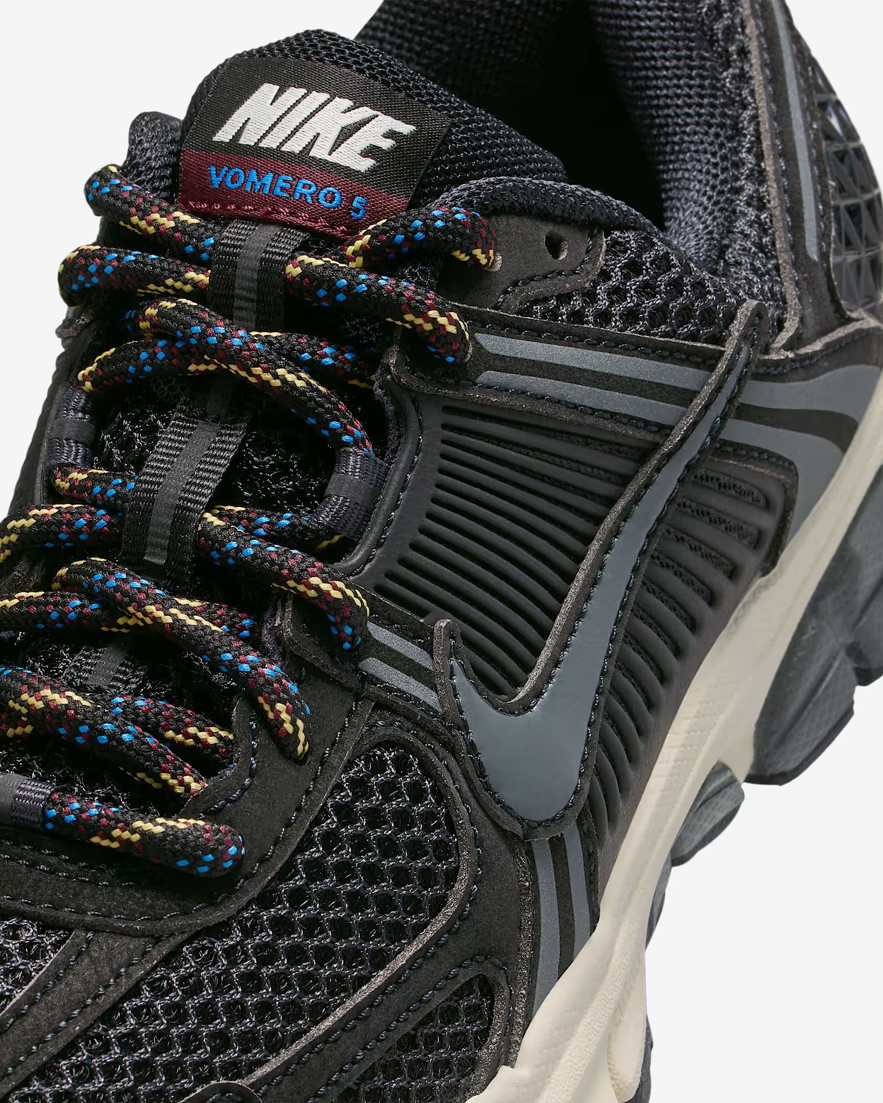 Close-up of a black Nike running shoe with multicolored laces and gray accents.