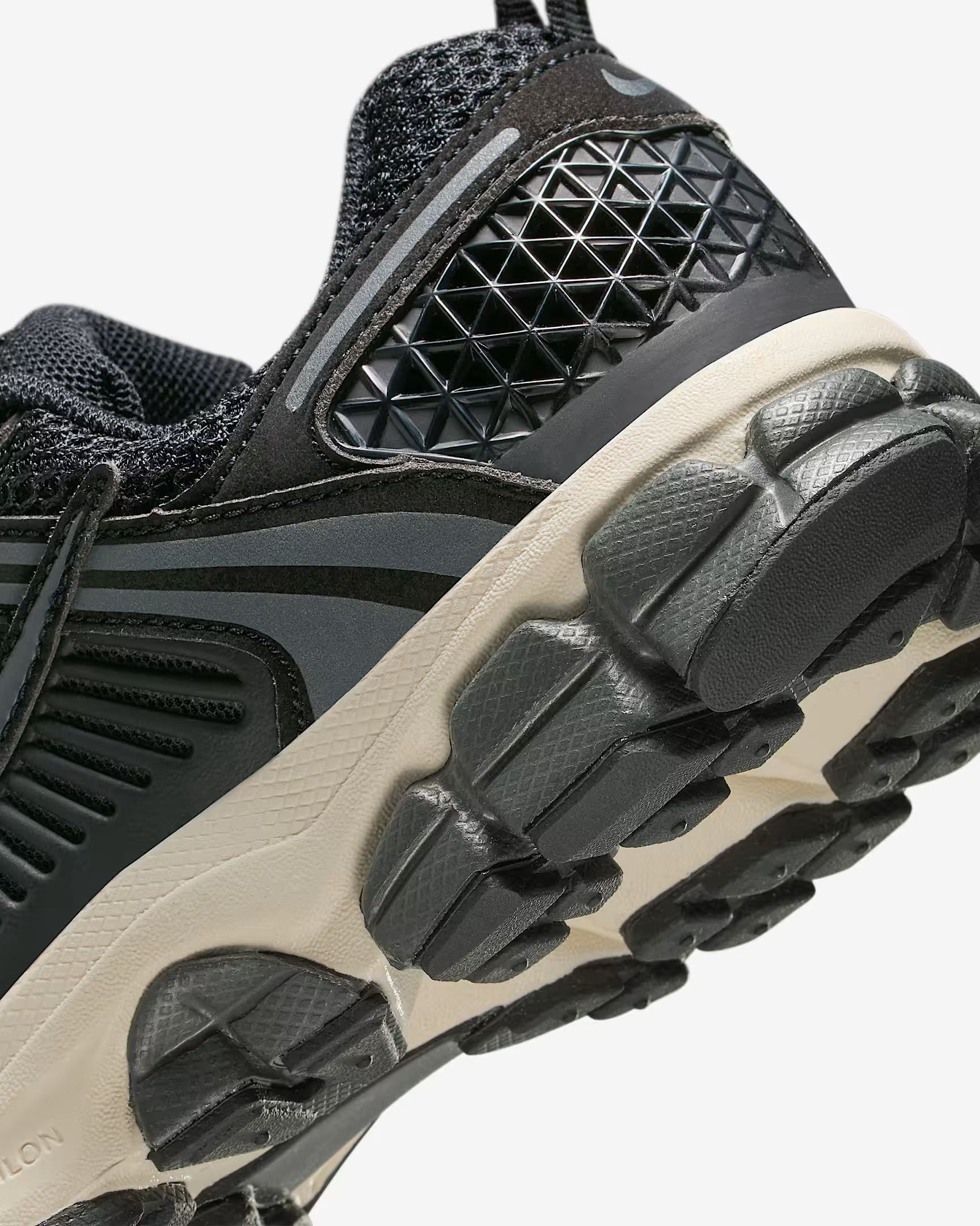Close-up of a black and gray running shoe, showing the textured sole and heel details.