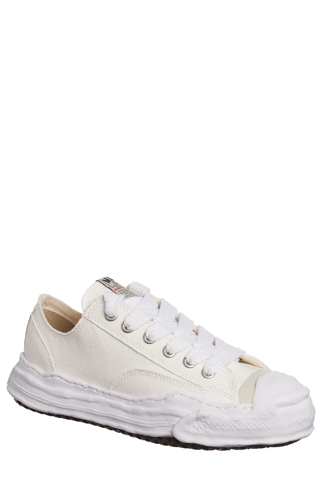 White low-top canvas sneaker with distressed rubber sole and toe cap.