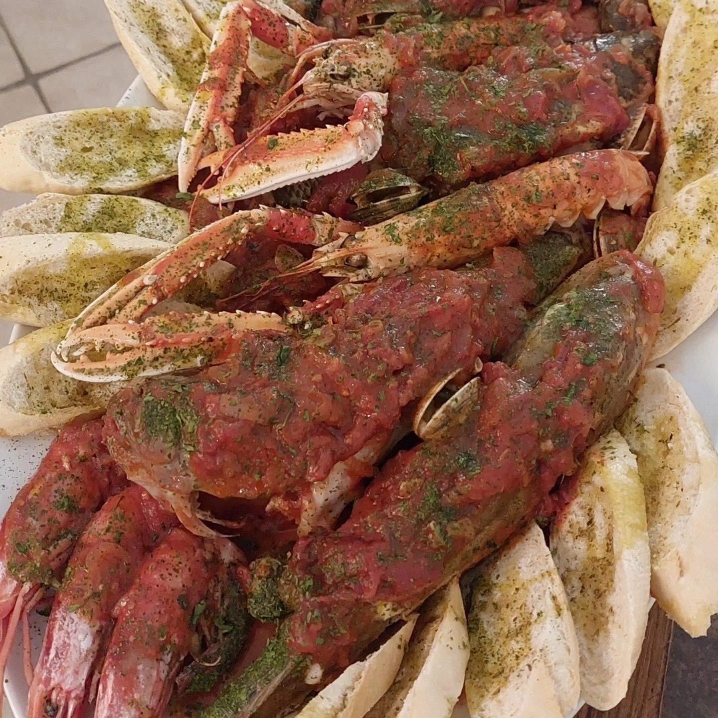 Chele di granchio impiattate, condite con salsa rossa ed erbe aromatiche e accompagnate da spicchi di limone.