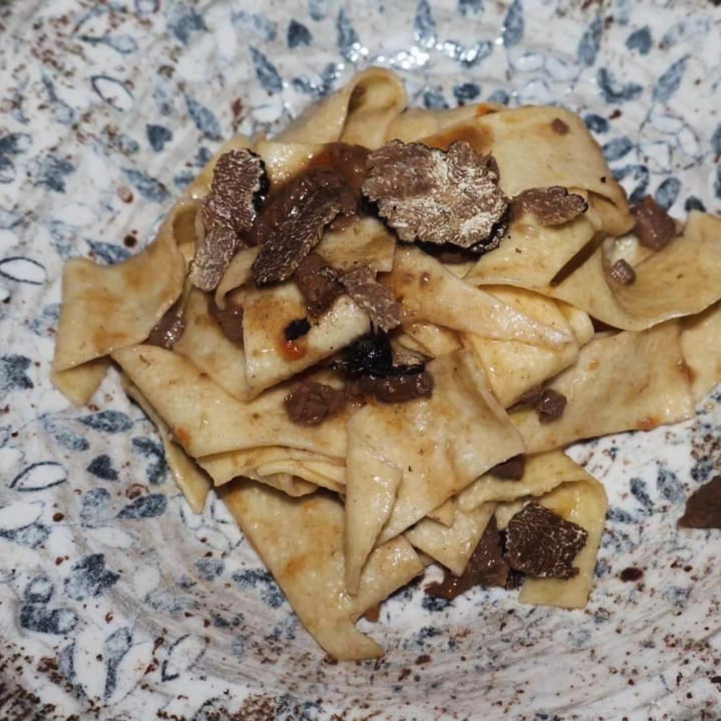 Nastri di pasta con carne rosolata in una ciotola maculata
