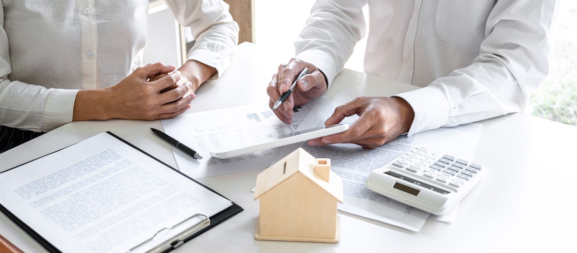 A man and a woman are sitting at a table looking at a piece of paper