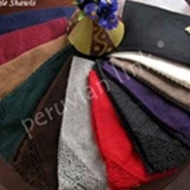 A collection of various colorful shawls, including red, purple, and green, displayed in a circular arrangement.