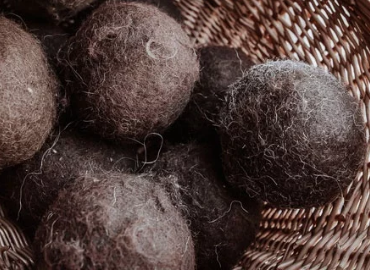 Brown wool dryer balls in a woven basket.