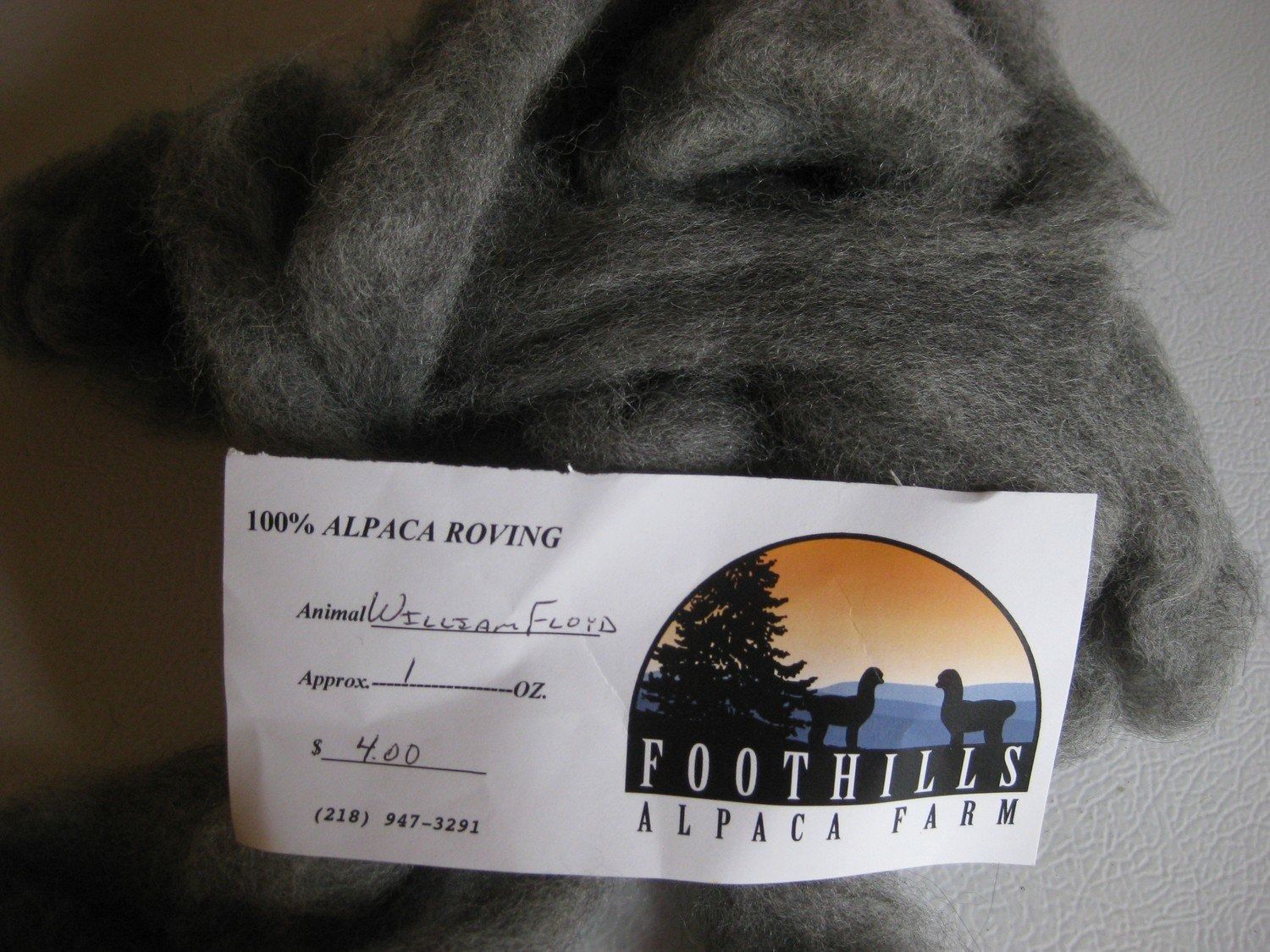 Gray alpaca roving with a label that reads "100% Alpaca Roving" from Foothills Alpaca Farm.