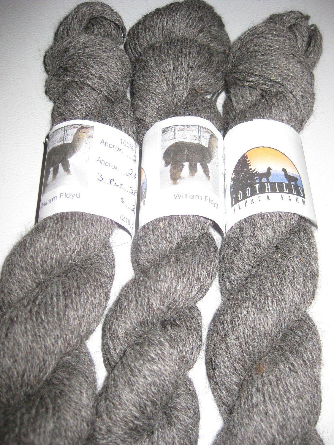 Three skeins of gray alpaca yarn with labels.