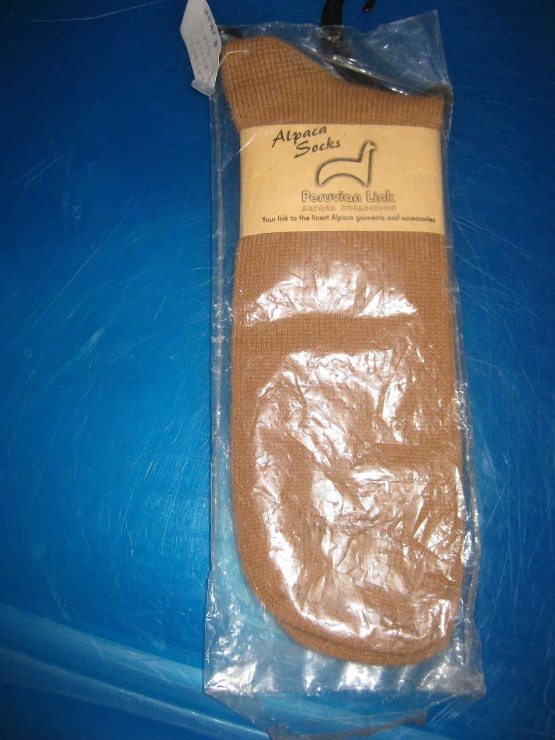 Alpaca socks packaged in clear plastic, with a brown label featuring a llama logo.