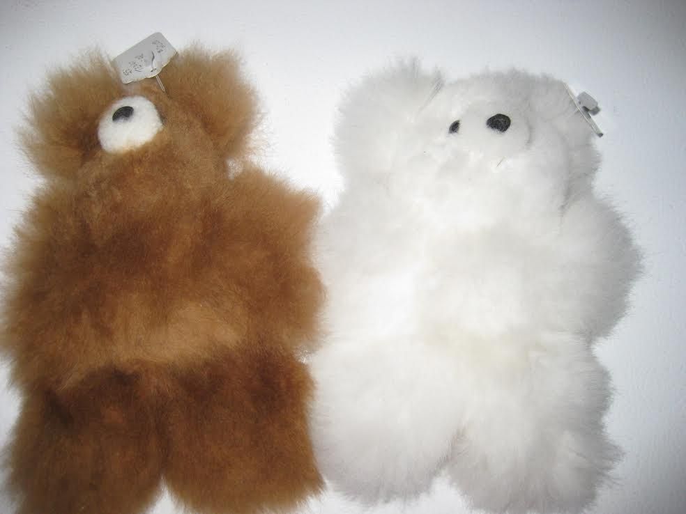 Two plush alpaca bears: one brown, one white, with small black eyes.