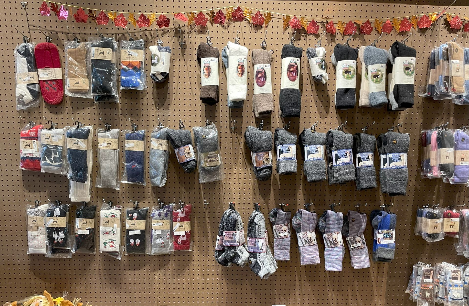 Rows of packaged socks hanging on a wooden display board; many different colors and patterns are visible.