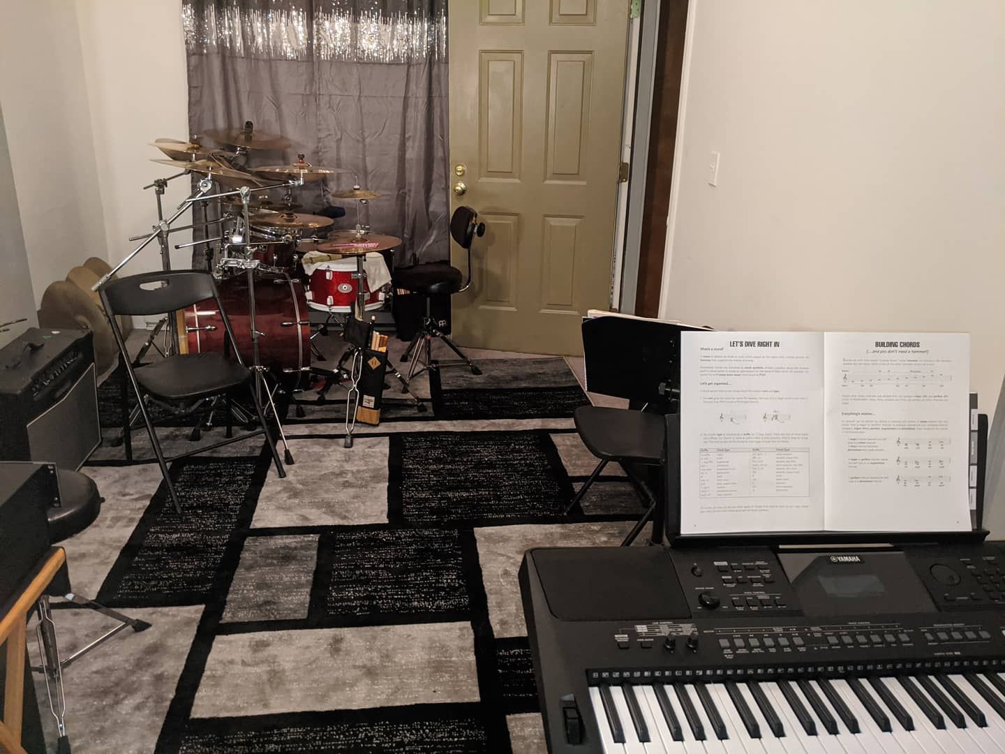 A room with a piano and a drum set in it