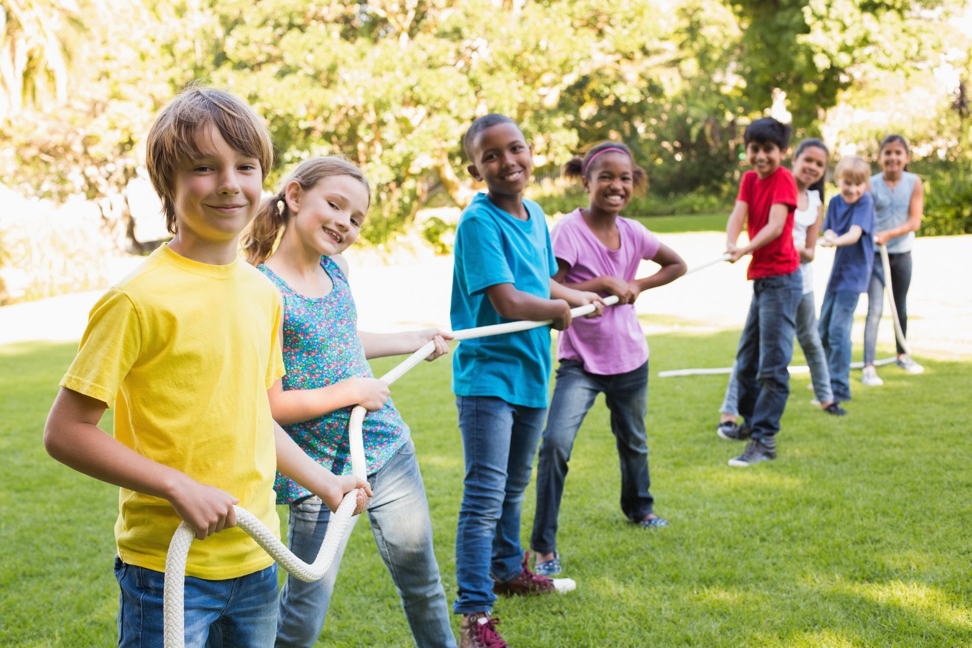 A group of children are playing tug of war with a rope