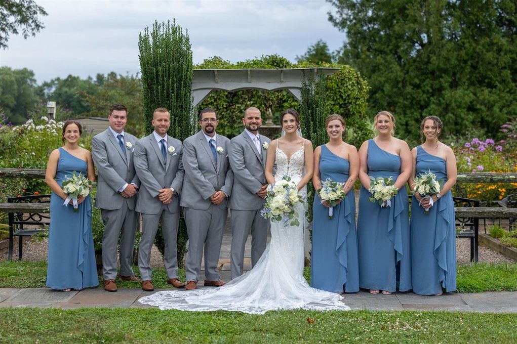The bride and groom are posing for a picture with their wedding party.