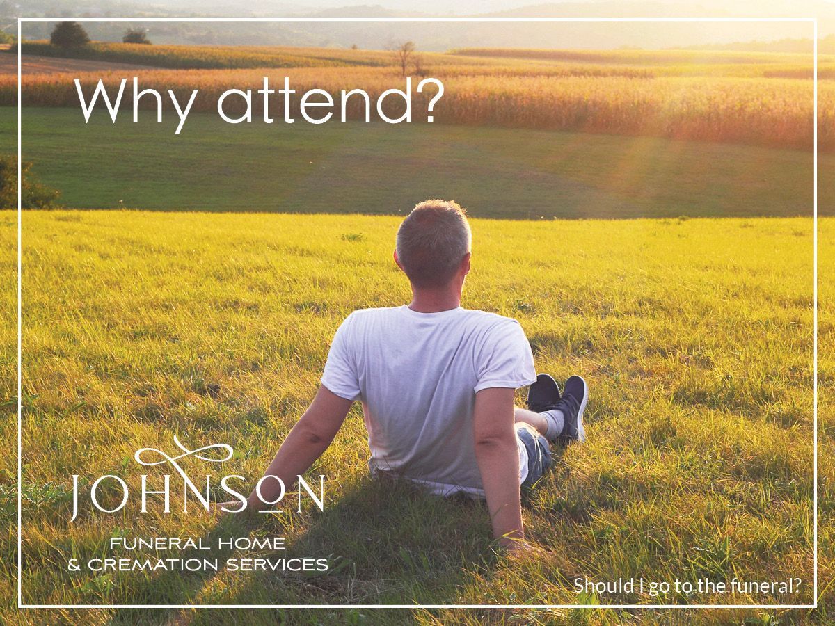 A man is sitting in the grass in a field.