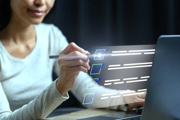 Silhouette of person with arms outstretched on mountain, sun rising.