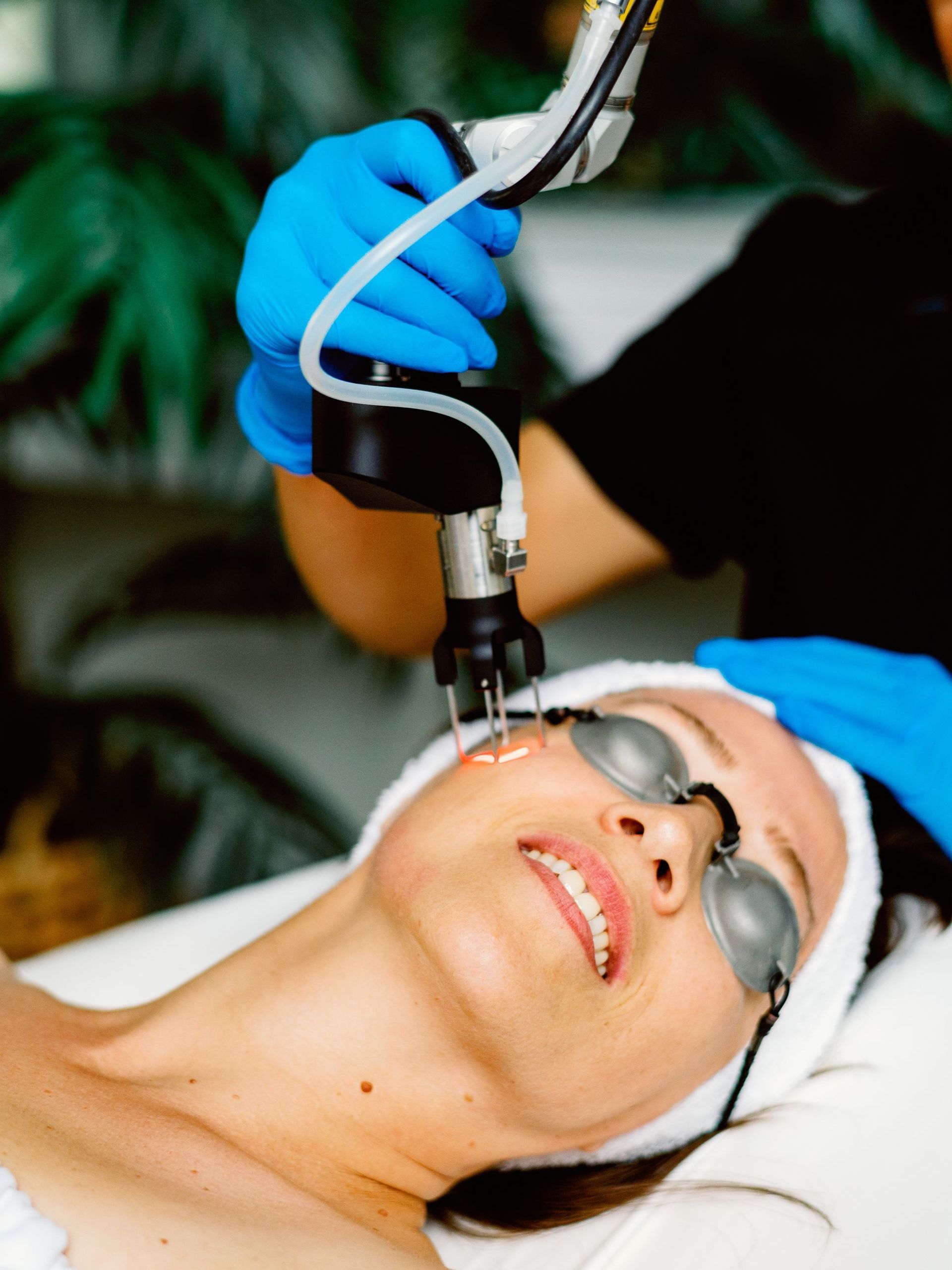 A woman is getting a laser treatment on her face.