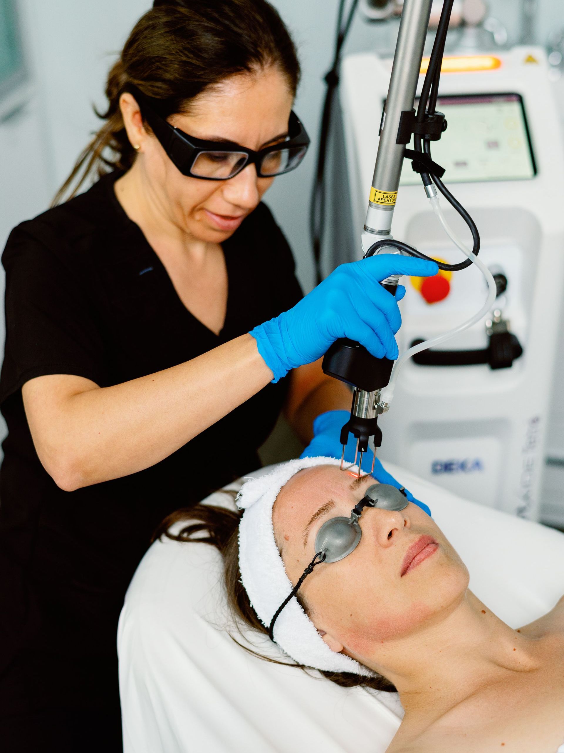 A woman is getting a laser treatment on her face