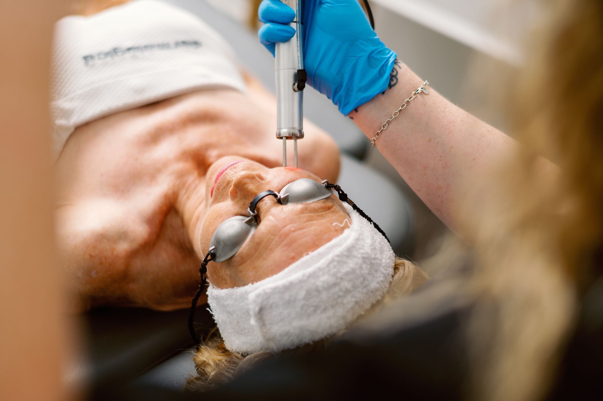 A woman is getting a laser treatment on her face.