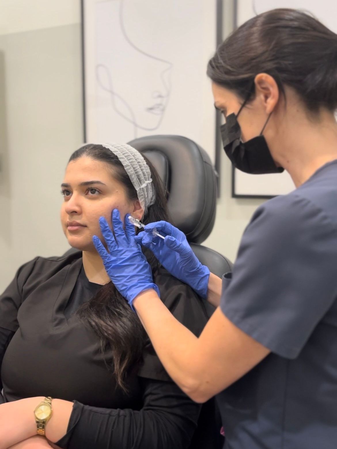 A woman is getting a botox injection in her face