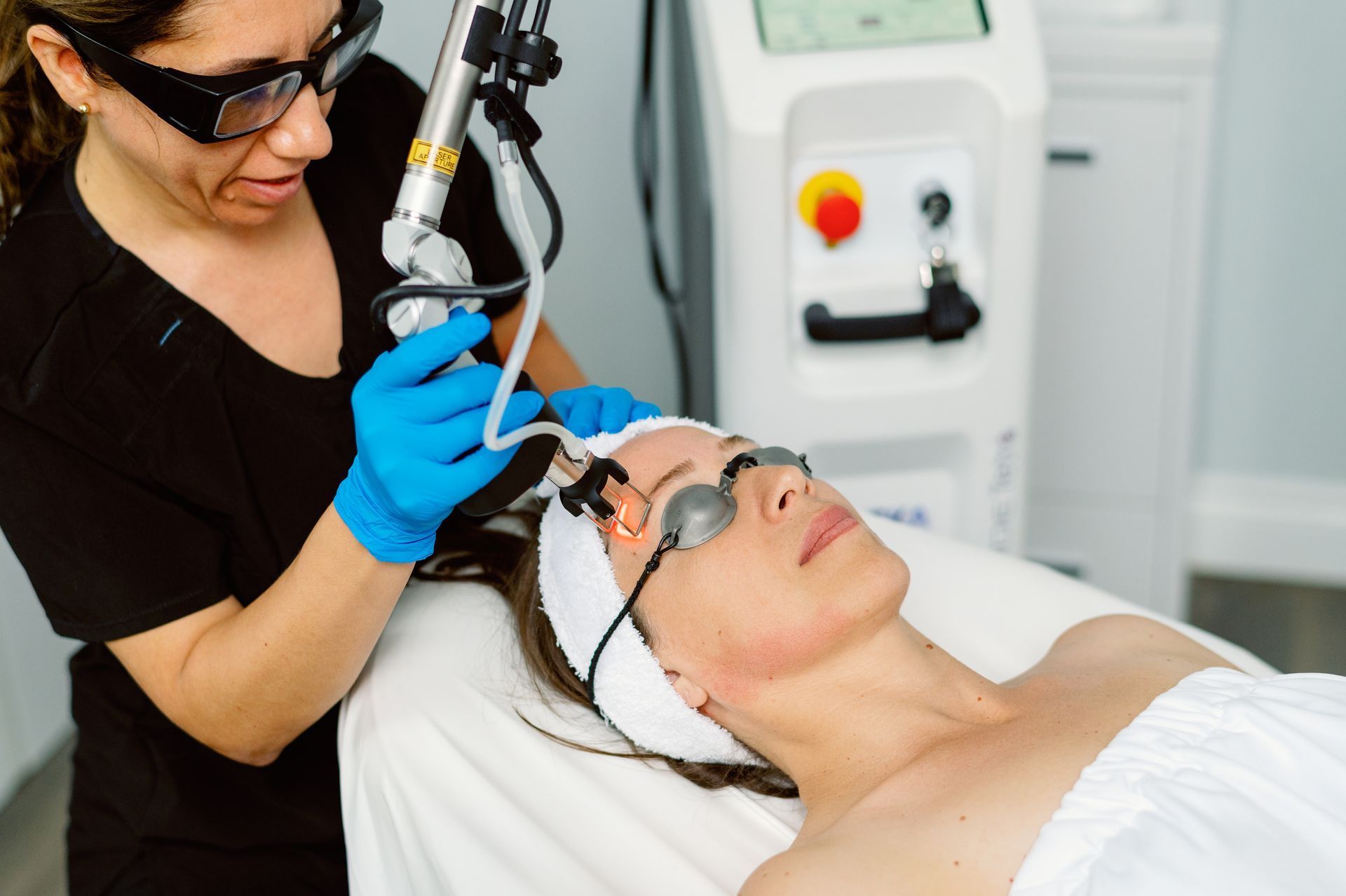 A woman is getting a laser treatment on her face.