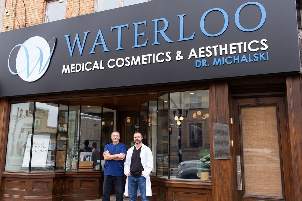 Two men are standing in front of a medical cosmetics and aesthetics store.