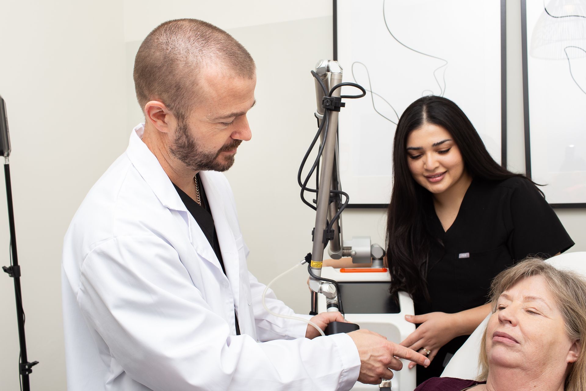 A doctor is talking to a patient while a nurse looks on.