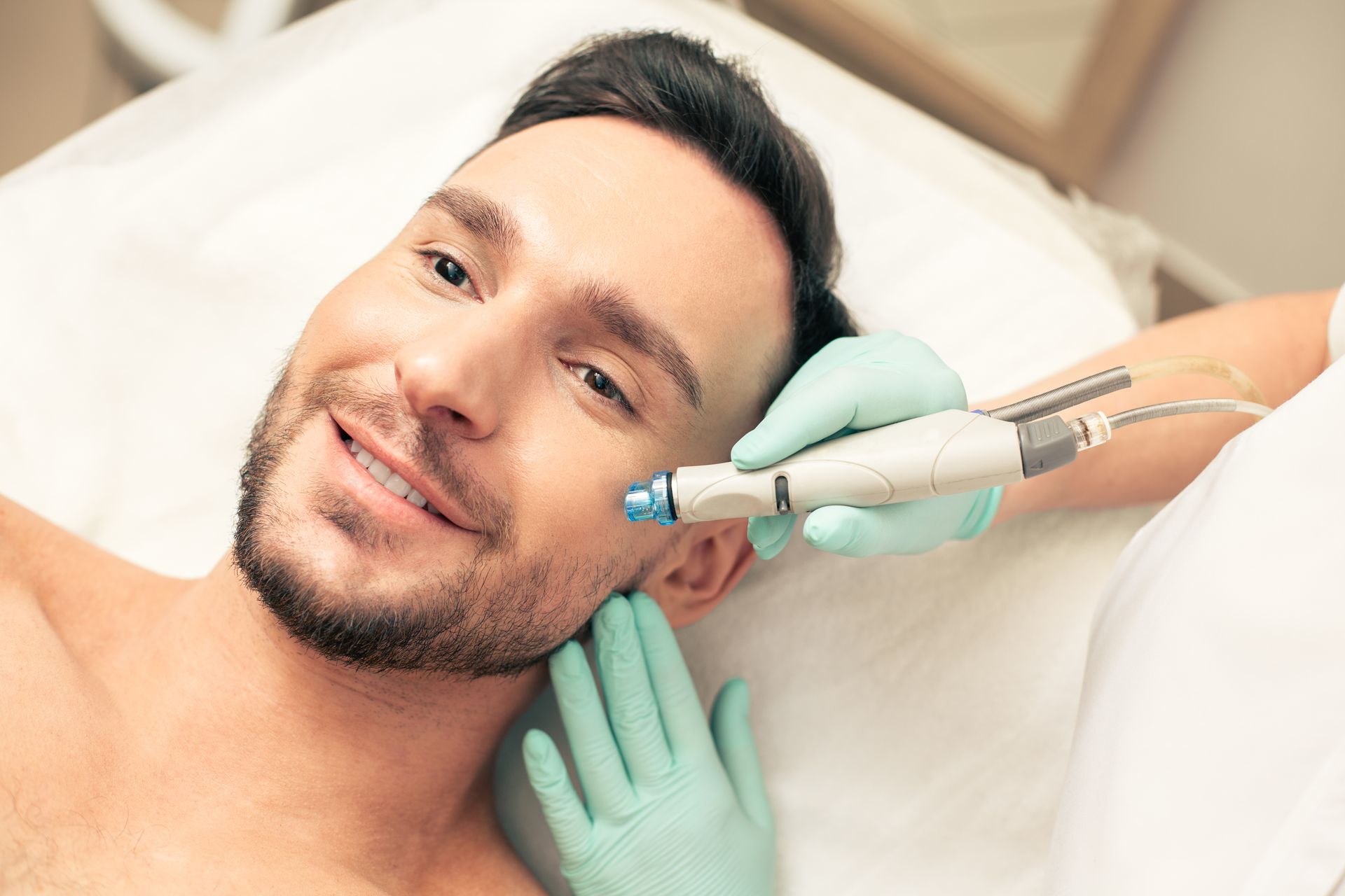 A man is getting a facial treatment in a beauty salon.