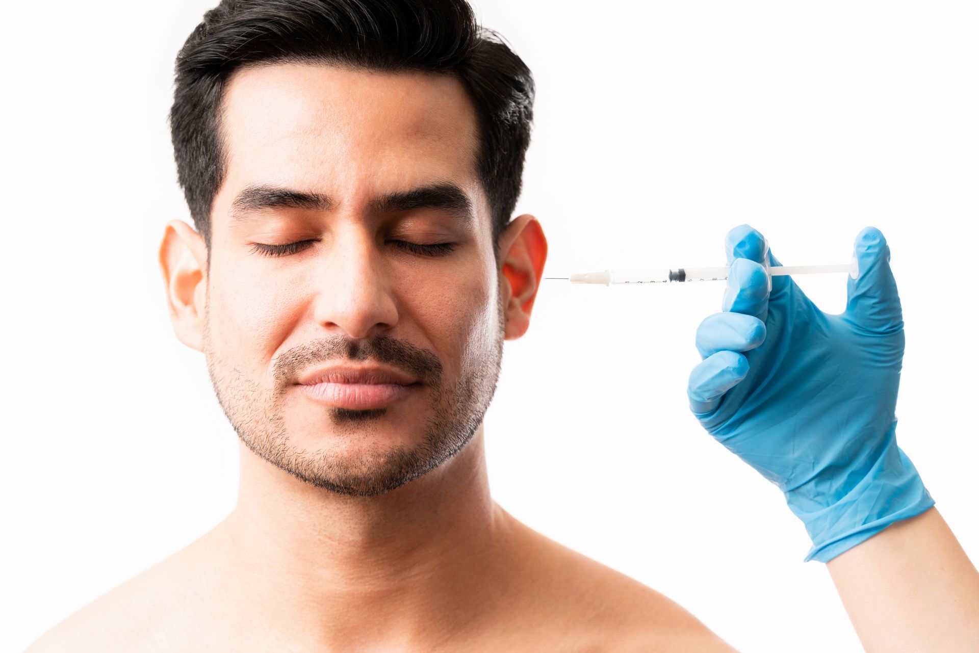 A man is getting a botox injection in his forehead.