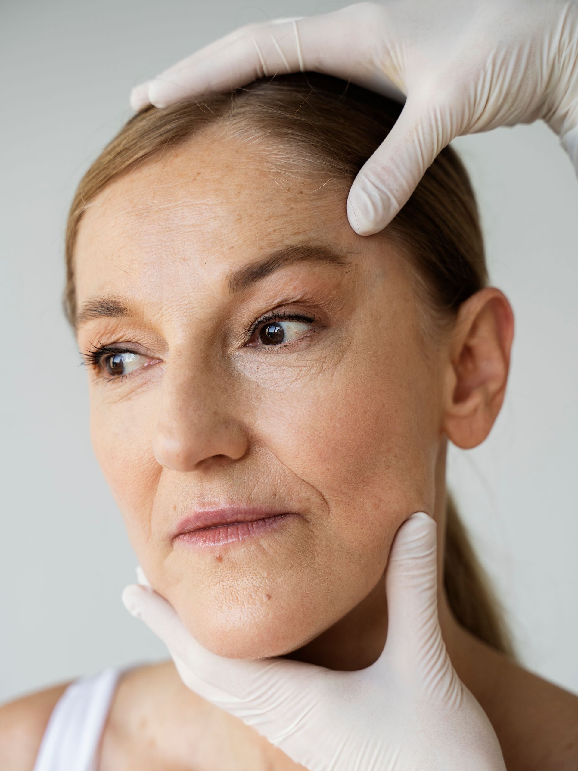 A woman is getting her face examined by a doctor.