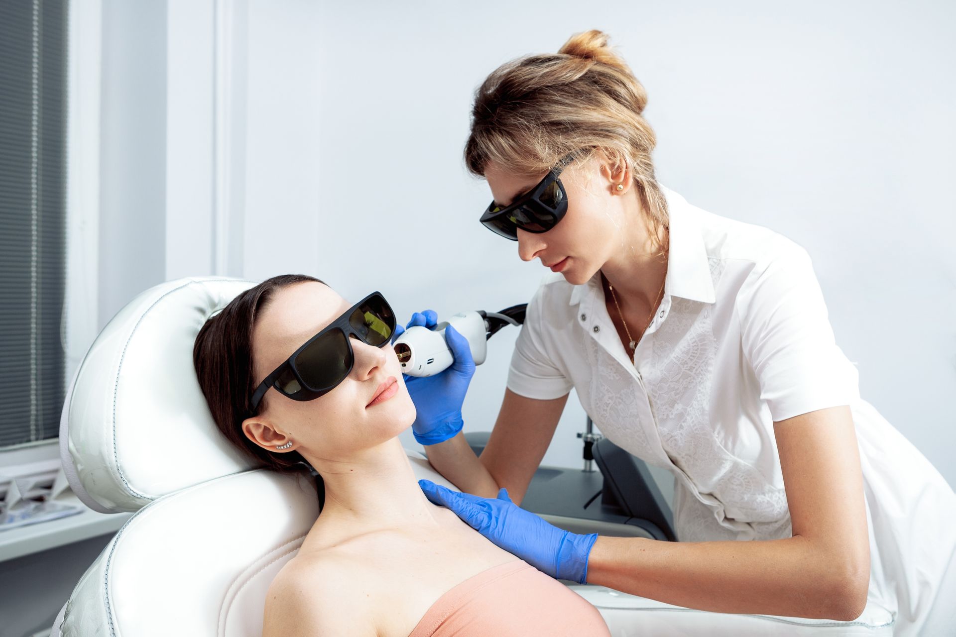 A woman is getting a laser treatment on her face.