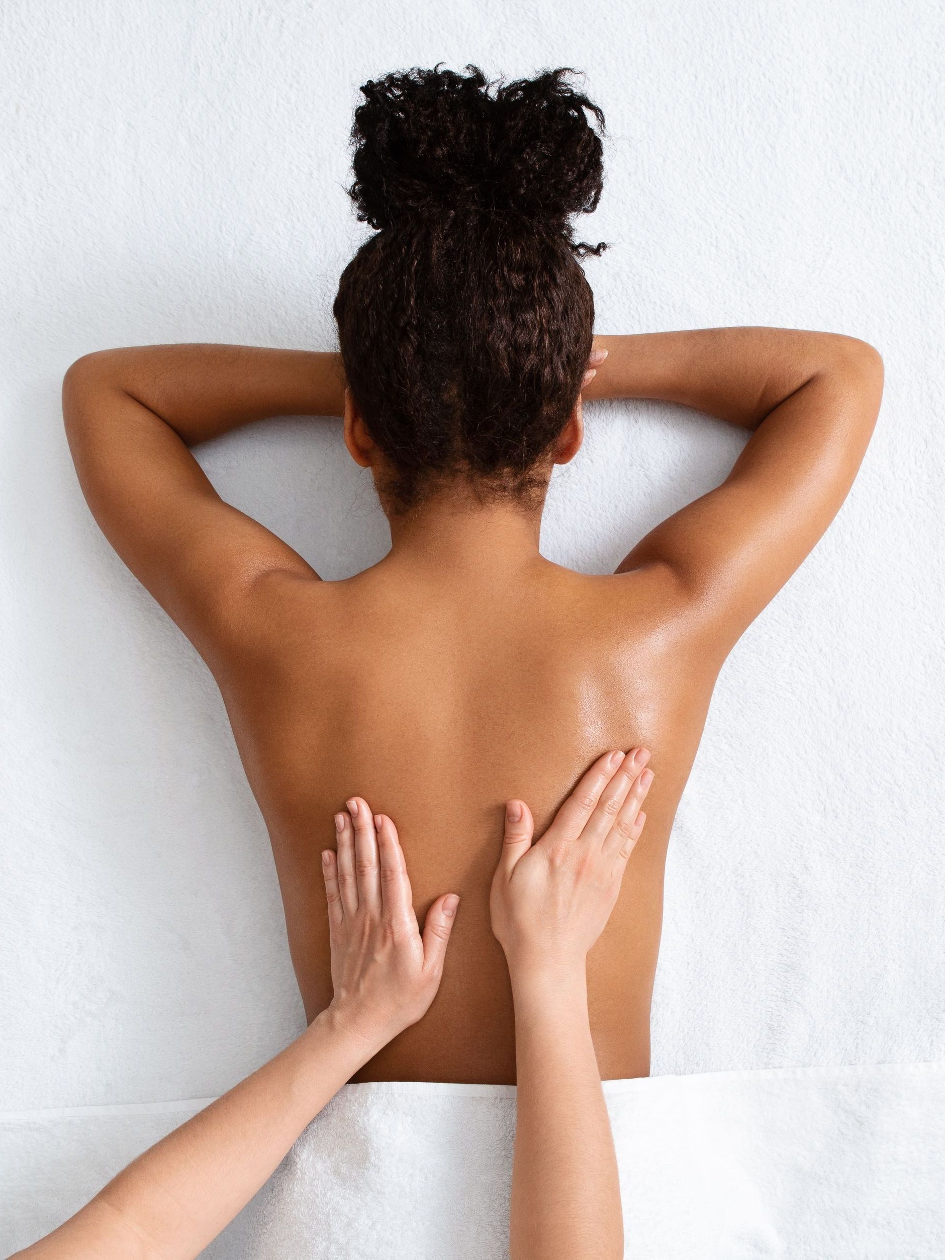 A woman is getting a massage on her back at a spa.