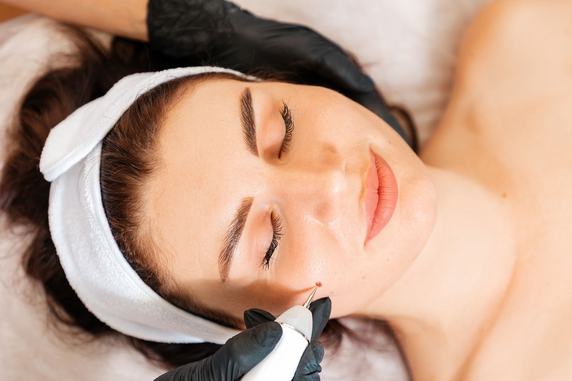 A woman is getting a facial treatment at a beauty salon.