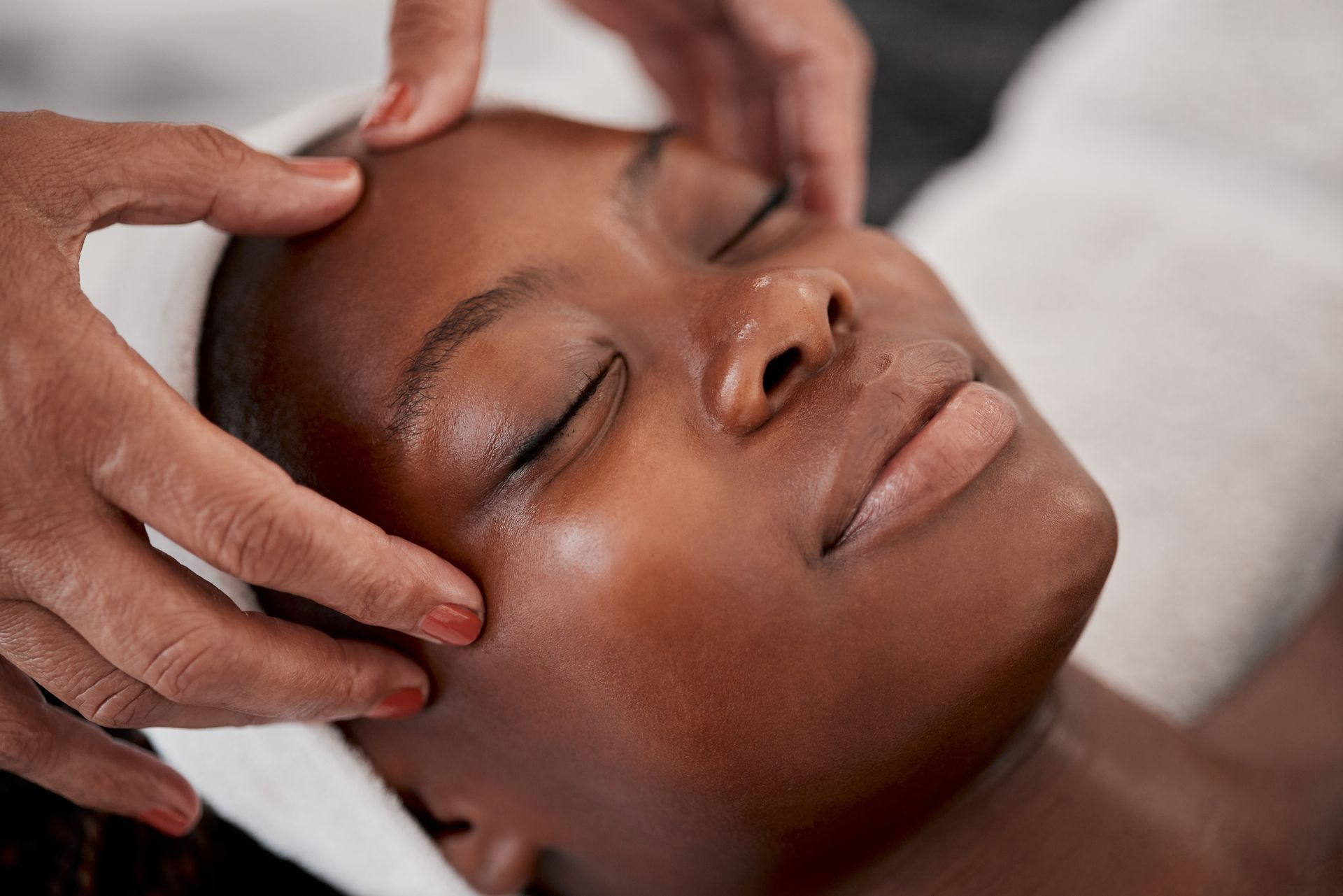 A woman is getting a face treatment at a spa.