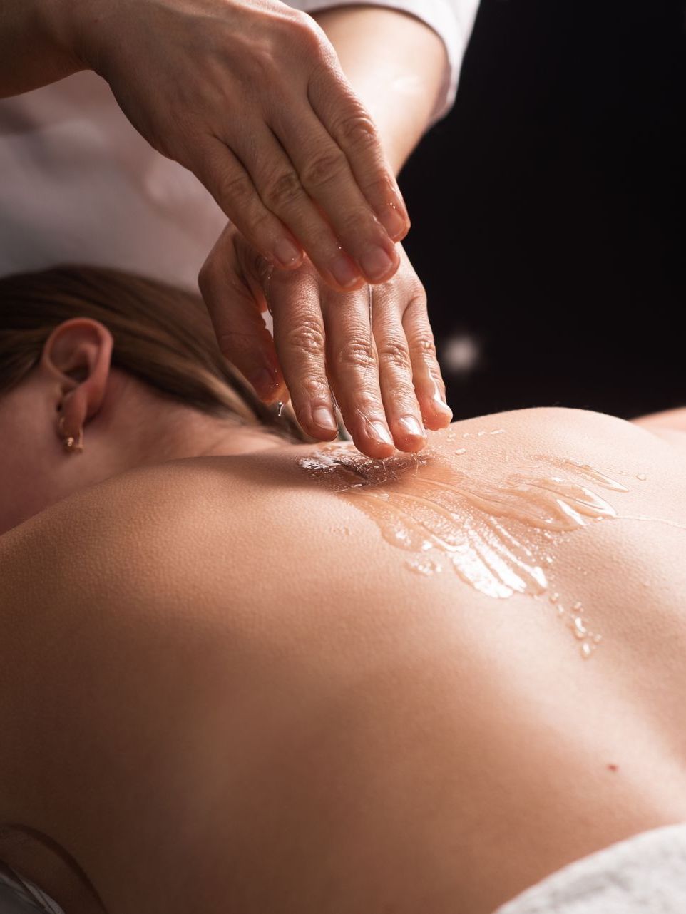 A woman is getting a massage on her back at a spa.