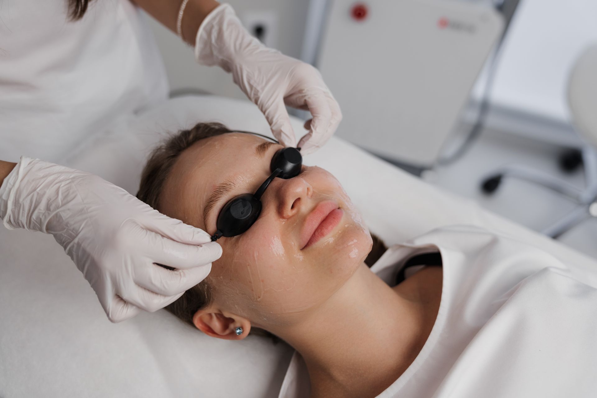 A woman is getting a laser treatment on her face.