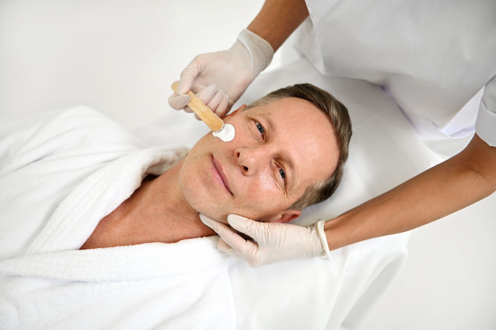 A man is getting a facial treatment at a spa.