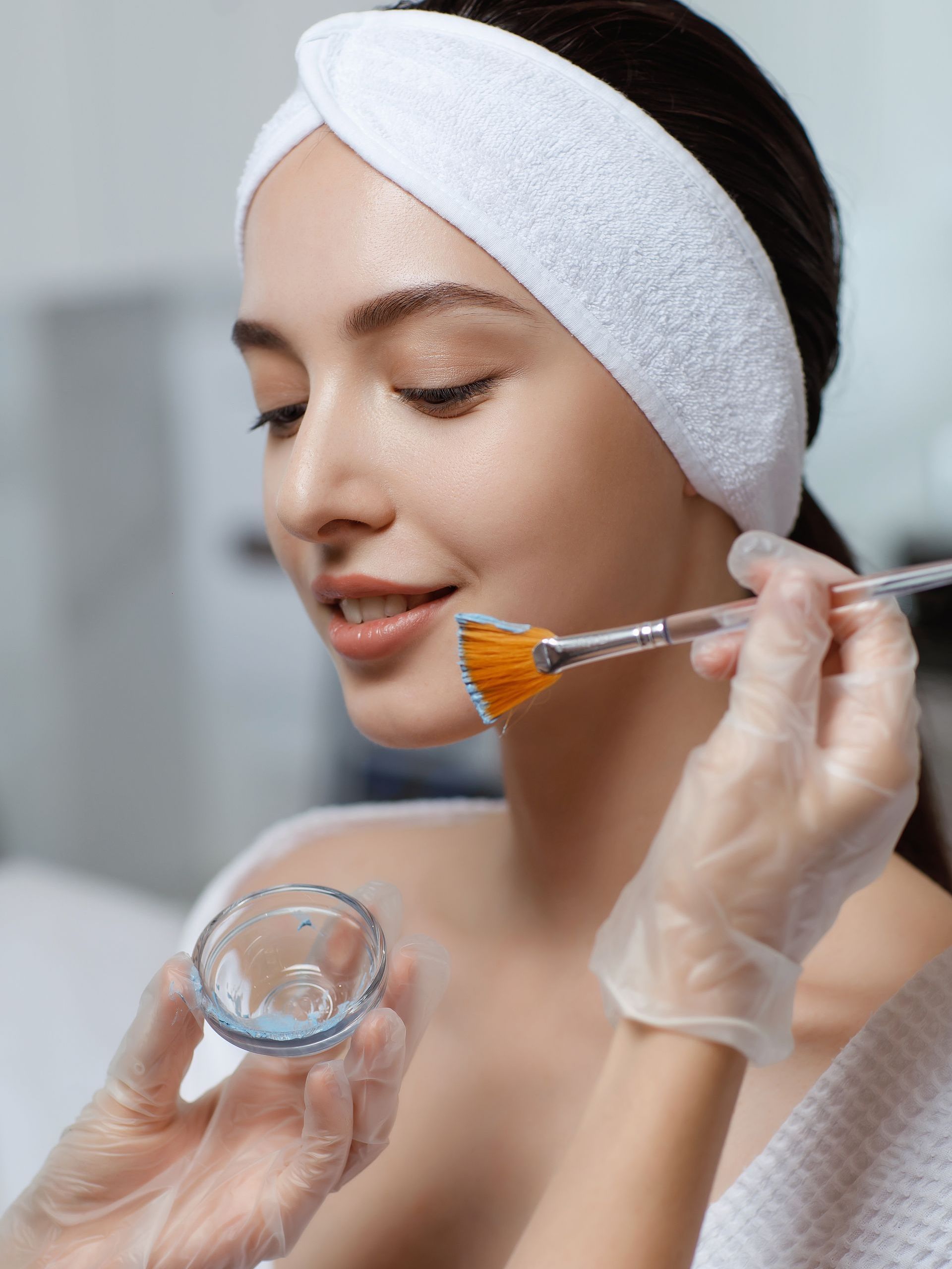 A woman is getting a facial treatment at a beauty salon.