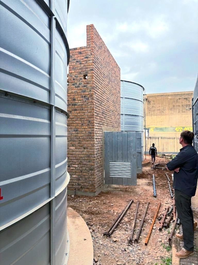 A man is standing in front of a building under construction.