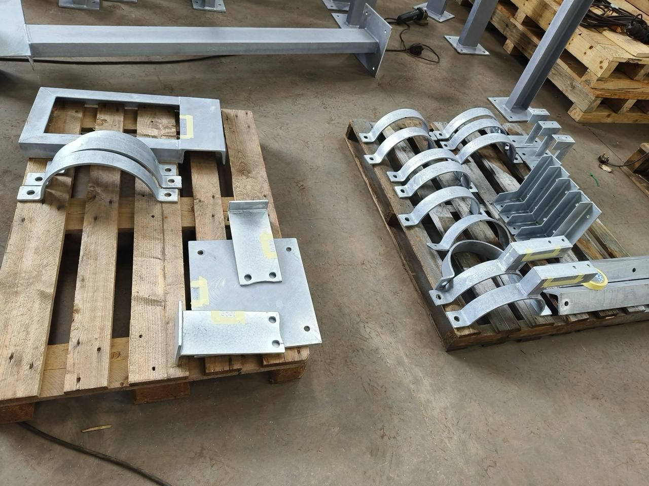 A bunch of metal parts are sitting on a wooden pallet