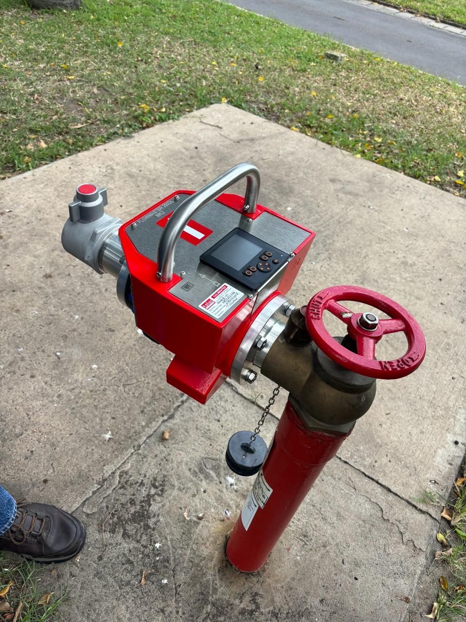 A red fire hydrant with a device attached to it.