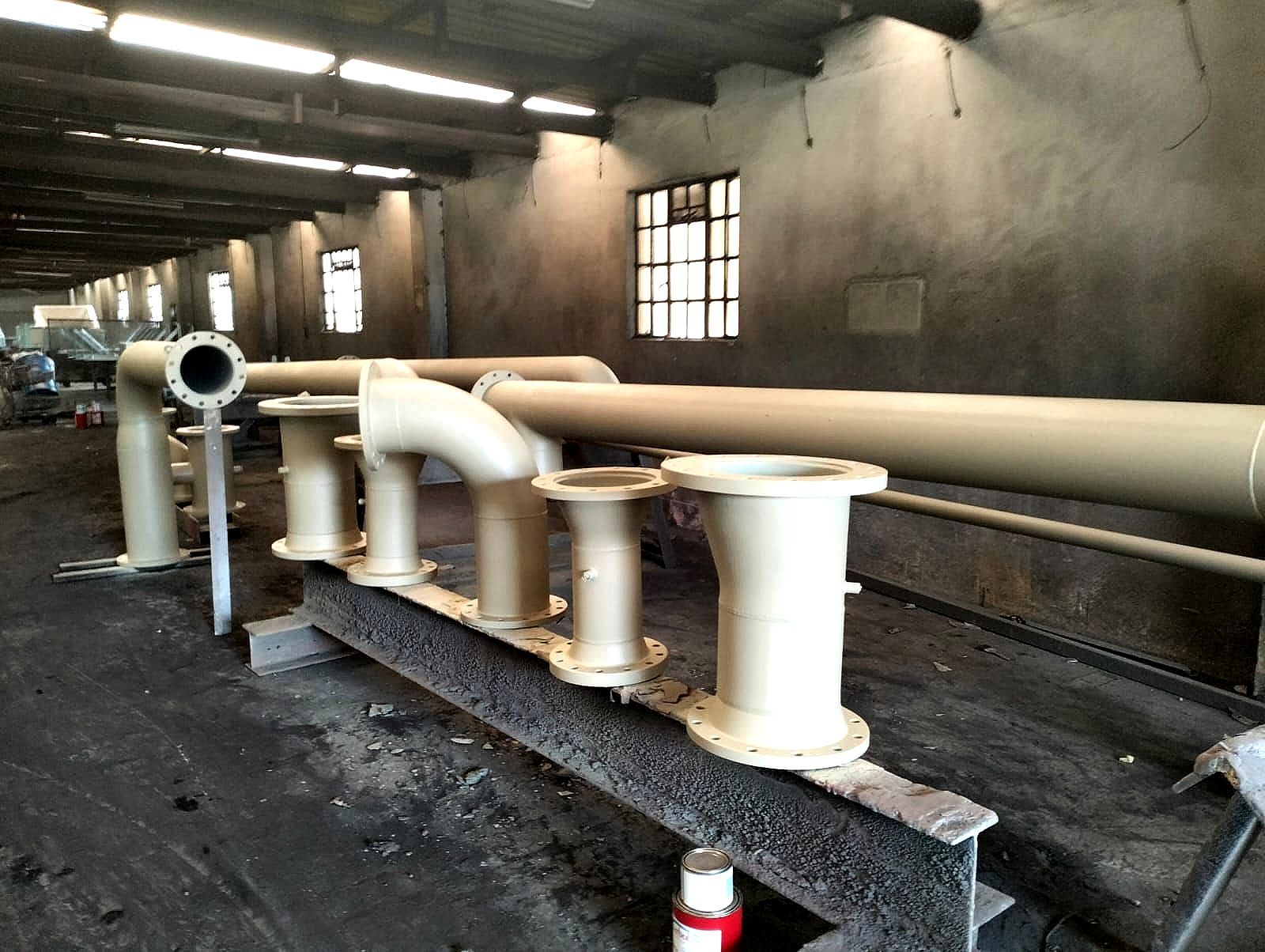 A bunch of pipes are sitting in a room with a window