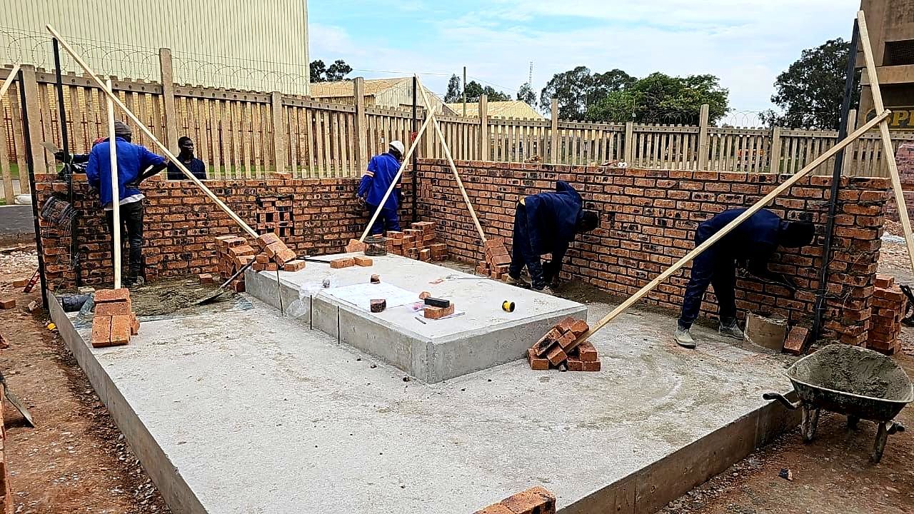 A group of construction workers are working on a brick wall.