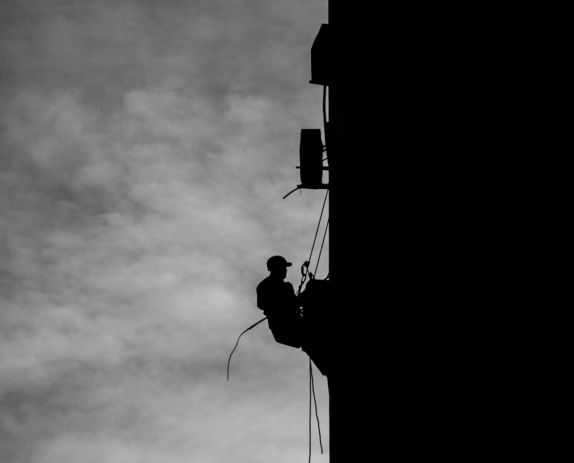 A man is climbing up the side of a building.