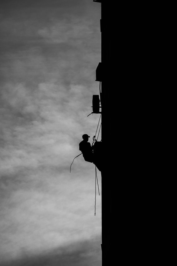 A man is climbing up the side of a building.