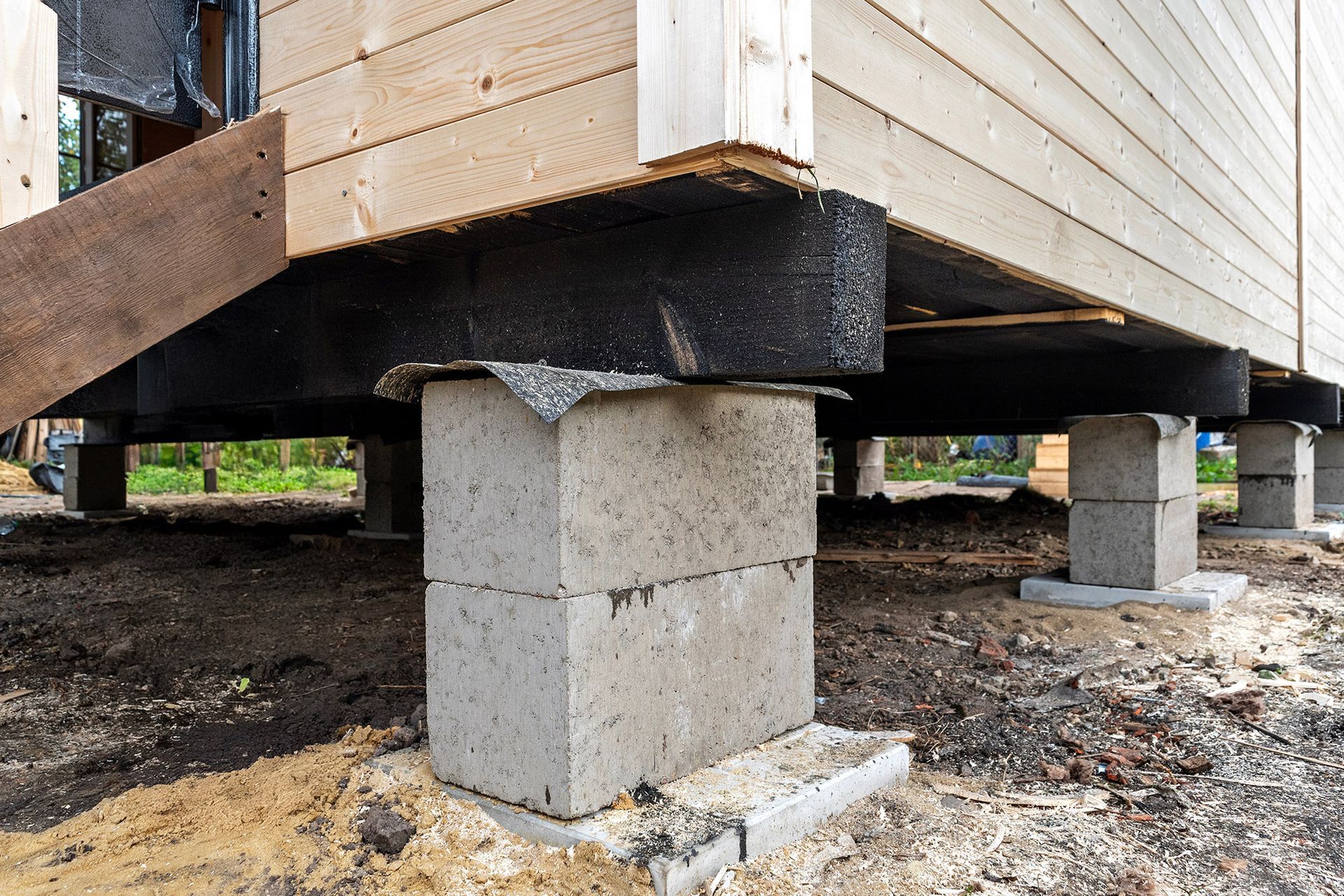 Wooden building supported by stacked concrete blocks; exterior shot.