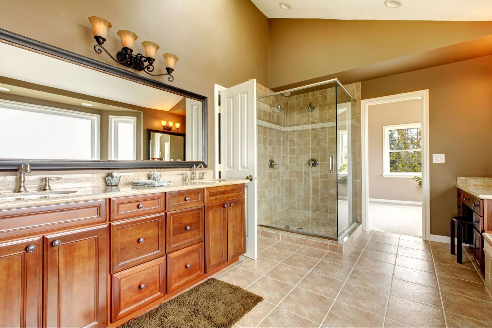 A bathroom with two sinks and a walk in shower.