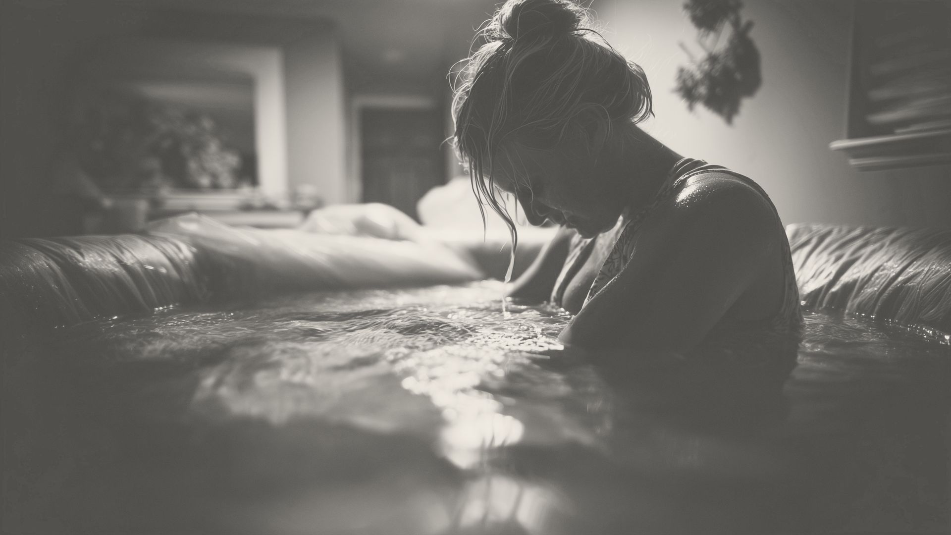Woman in labor in water birth tub.