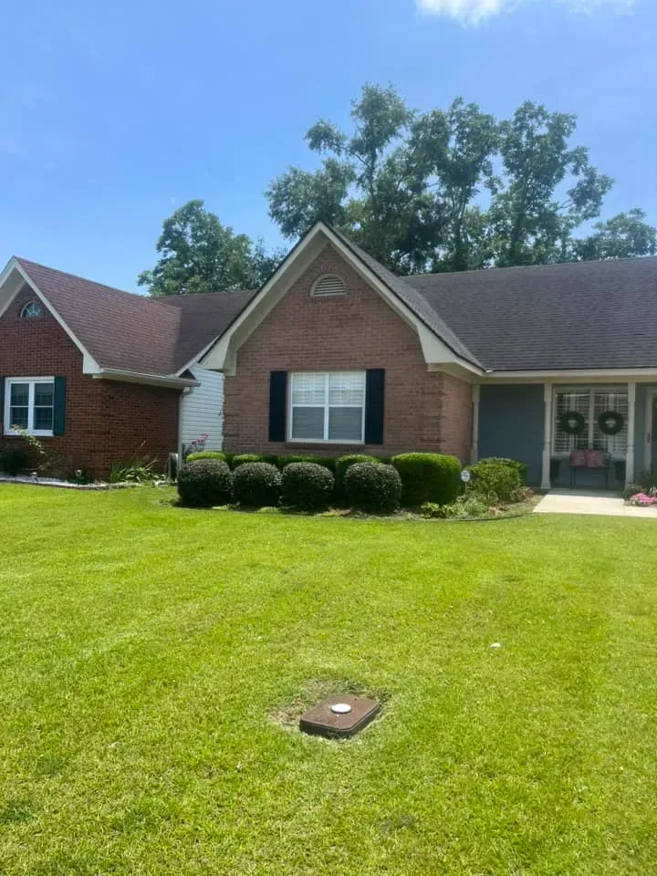 A brick house with a large lawn in front of it