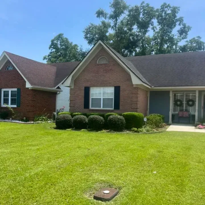 A brick house with a large lawn in front of it