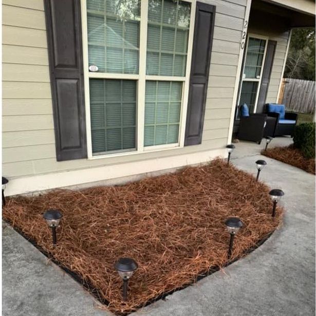 A house with a large pile of pine needles in front of it